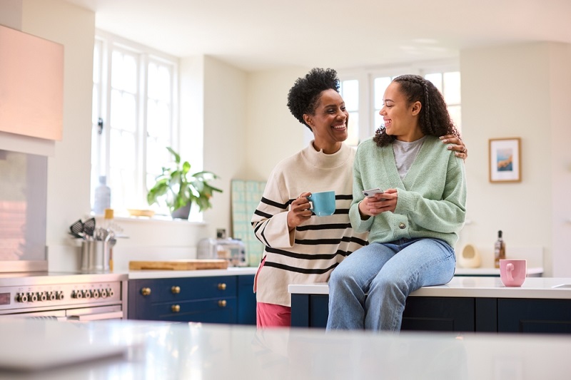 Mother and daughter having conversation in kitchen